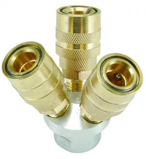 A group of three brass couplings sitting on top of a metal object.