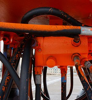 A close up of the hydraulic system on an orange tractor.